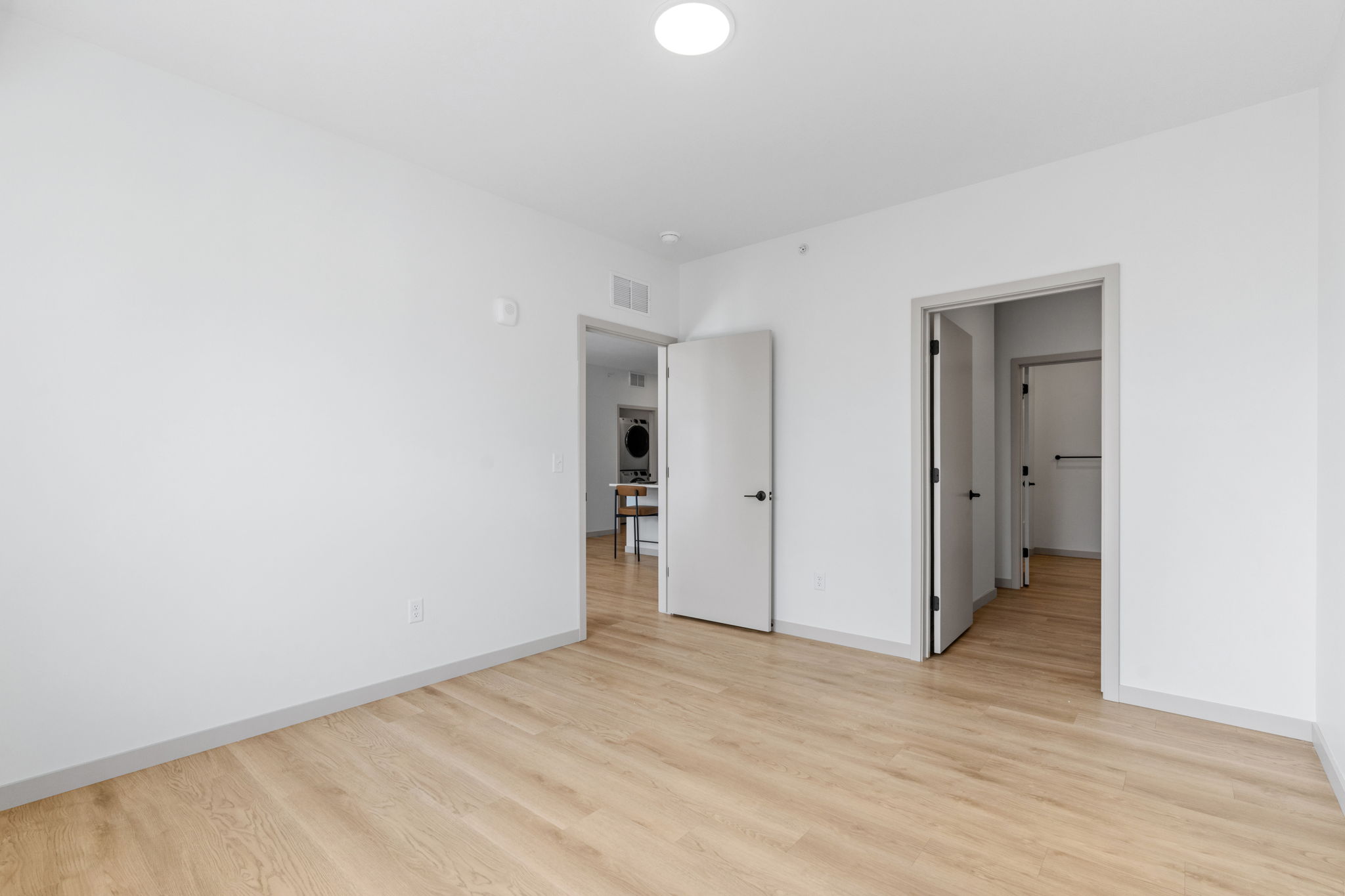 Laundry nook with washer dryer and closet-style door inside apartment