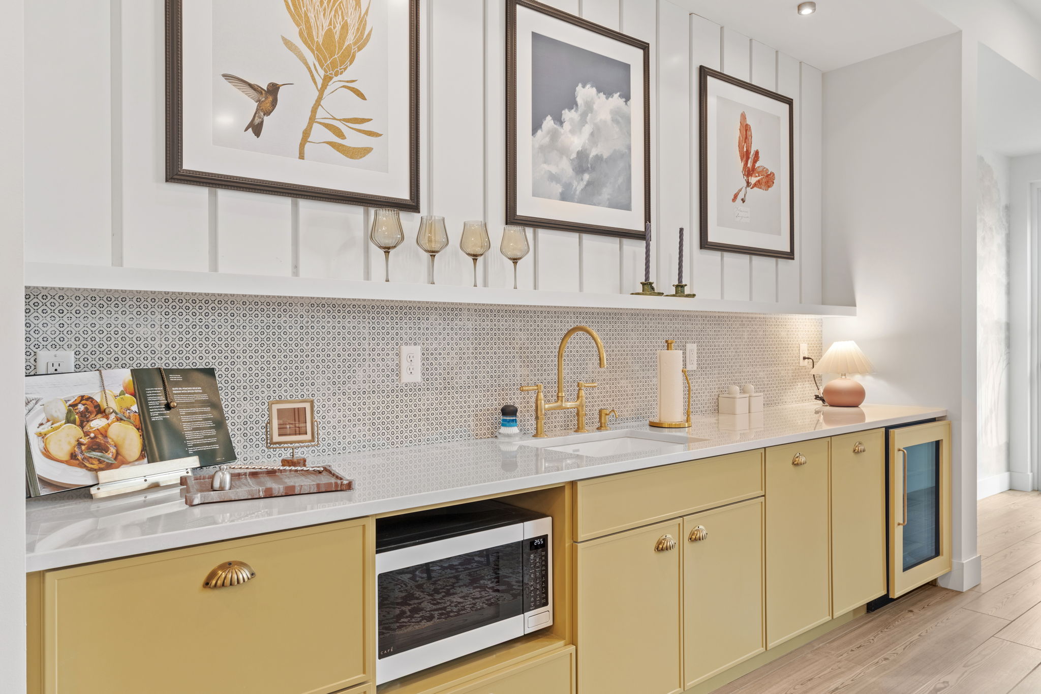 Community room wet bar with gold cabinets and decor