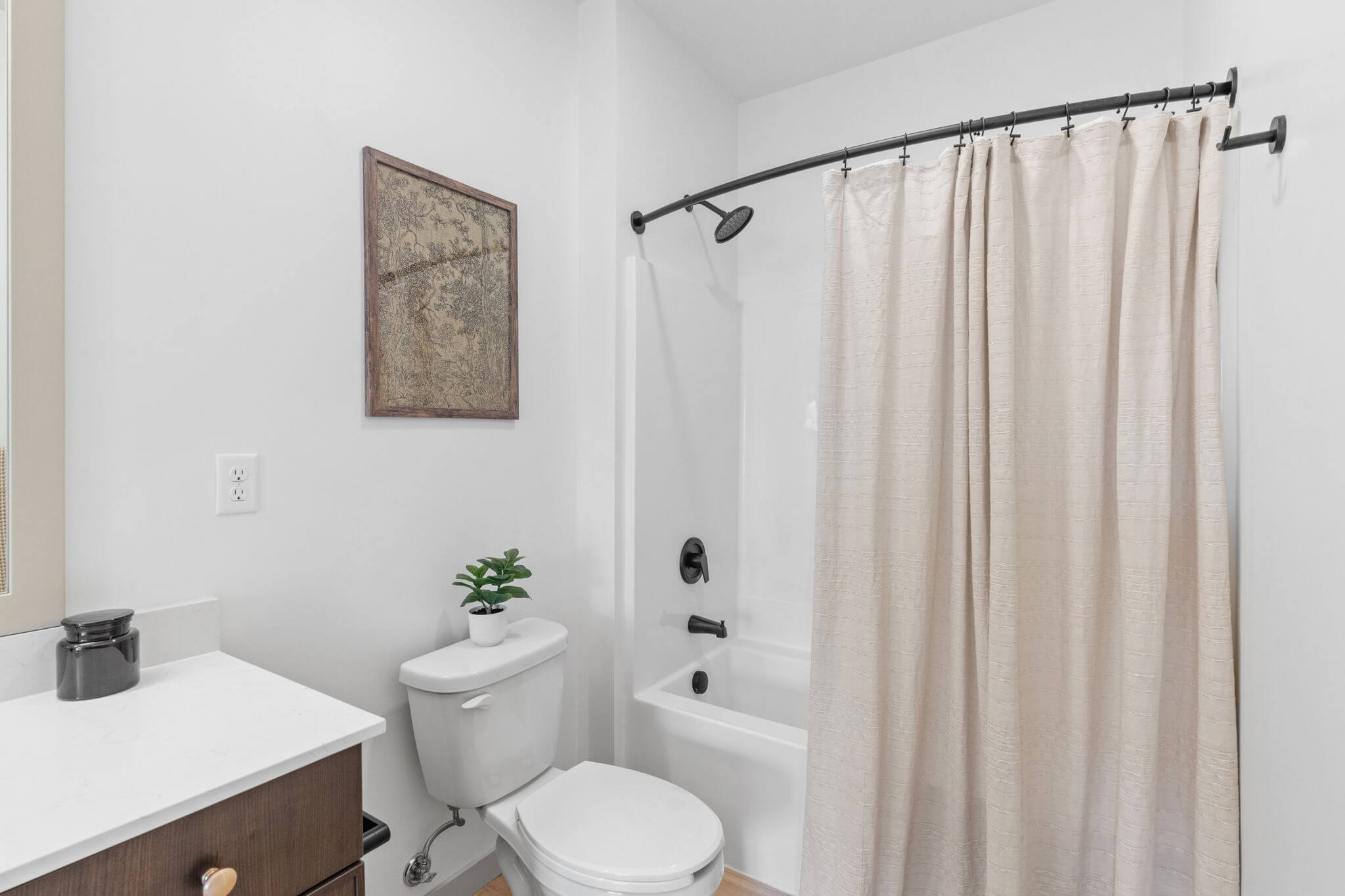 Bathroom with white shower curtain and wood-style flooring