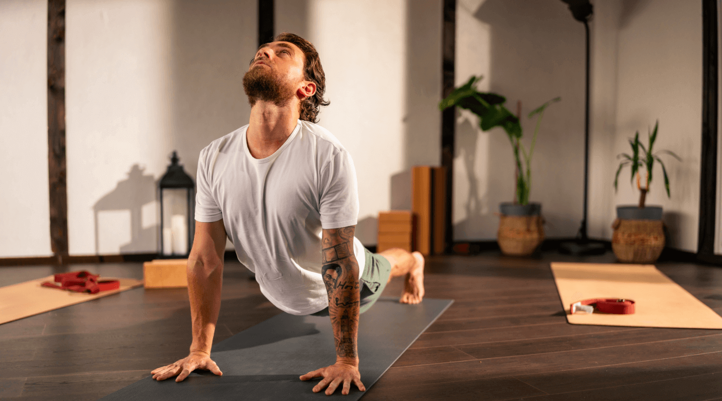 Man doing a yoga pose indoors on a mat
