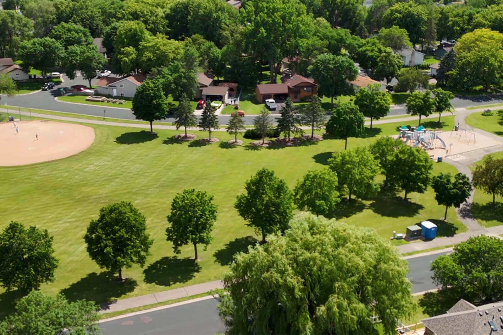 Aerial view of a suburban park with playground and ball field