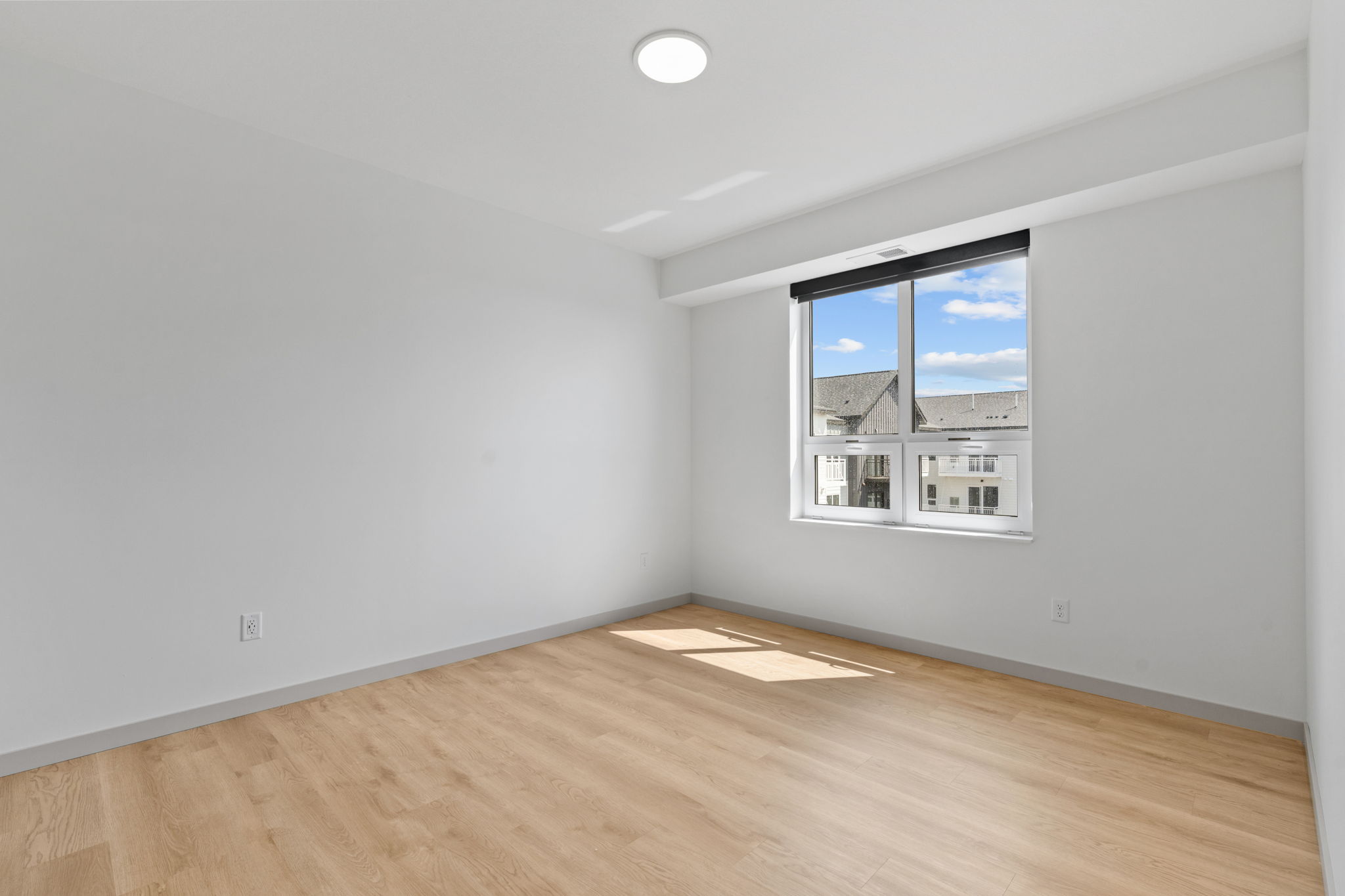 In-unit stacked washer and dryer with adjacent shelving inside Rye Apartments